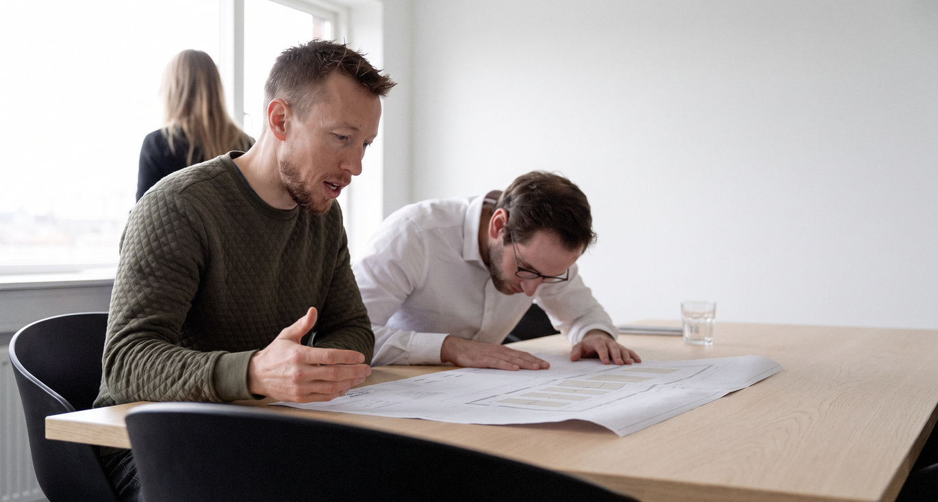 Technisch verantwoordelijke en adviseur bespreken de NIS2-verplichtingen voor een nutsbedrijf.