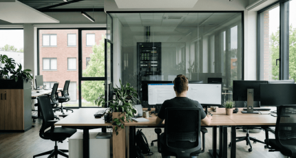 Een modern kantoor van een Vlaams bedrijf waarbij op de achtergrond de IT-infrastructuur en serverkast zichtbaar zijn; Cyberplan voert hier audits uit om de 80% veelvoorkomende firewall configuratiefouten op te sporen."